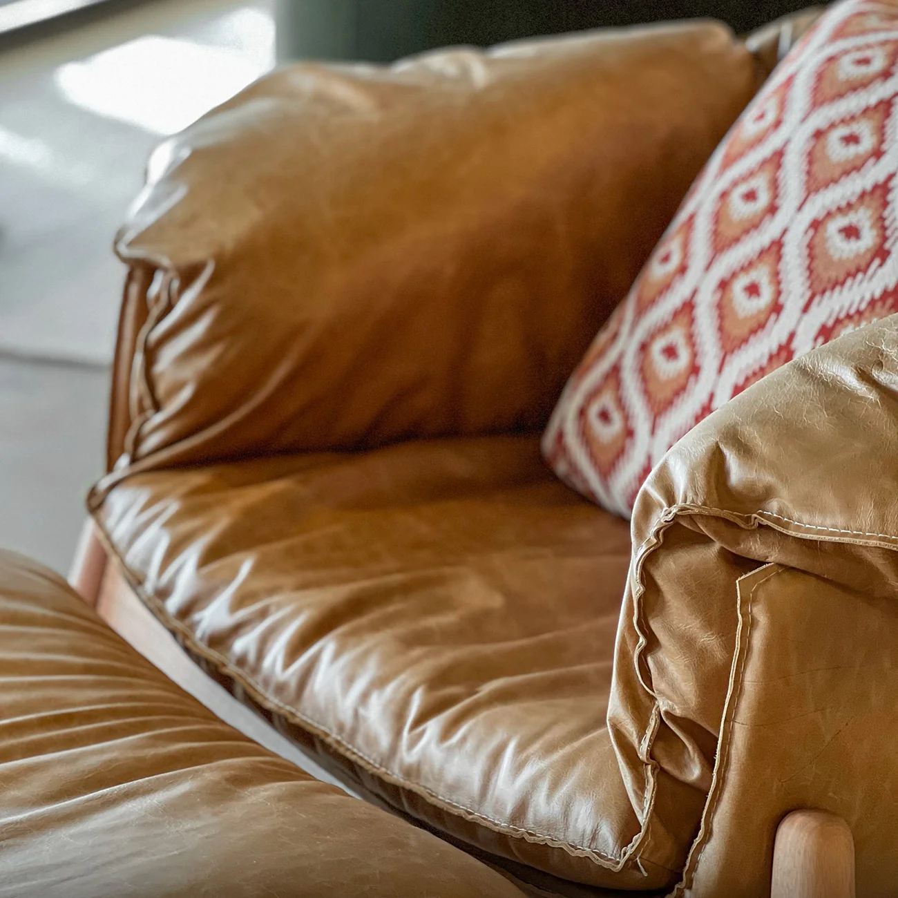 كرسي عصري بذراعين وجلد طبيعي مع مسند للقدمين